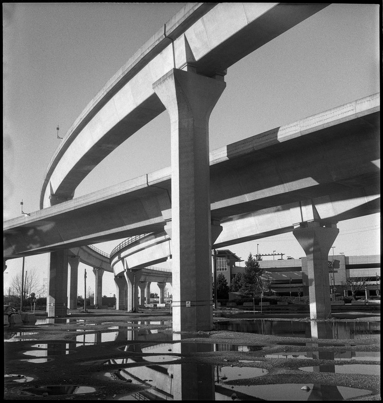 Overlapping train flyways are reflected in shallow puddles.