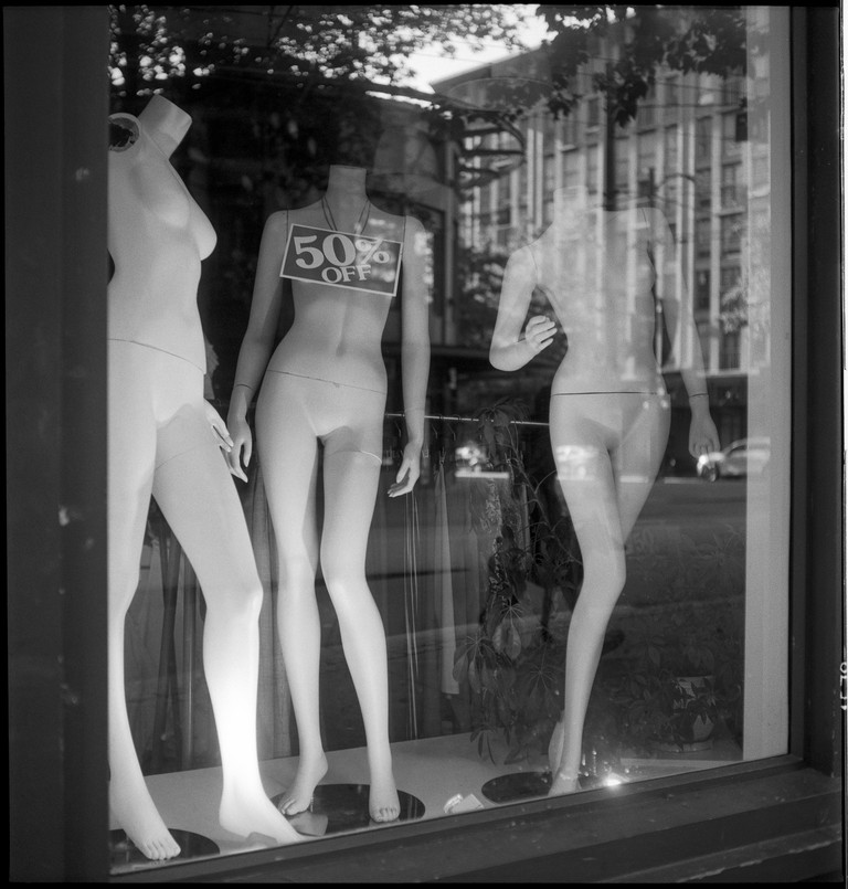 Mannequins bare all. One wears a 50% off sign.