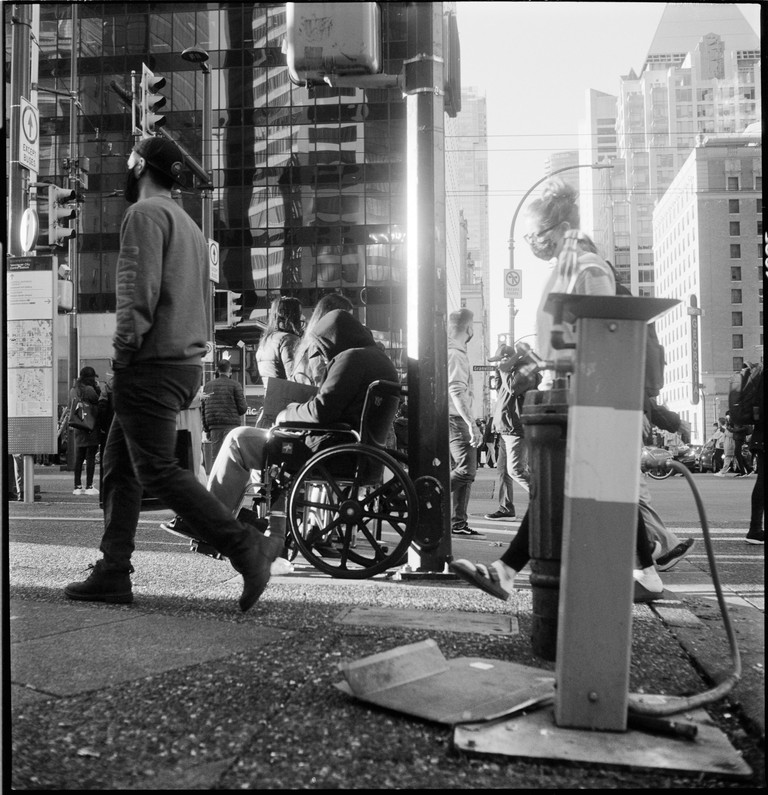 Layers of pedestrians pass at a busy Vancouver intersection.